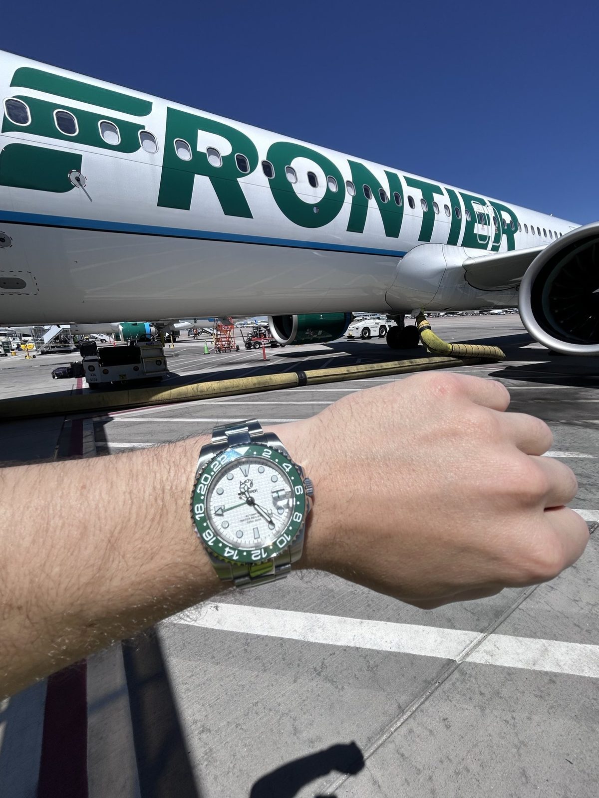 Somerada green-bezel GMT in front of a Frontier tail